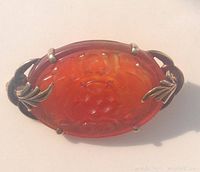 Front view on white background showing carved carnelian and gold prongs