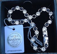 Silver-tone bracelet with alternating clear round crystals and black enamel rings in box with Swarovski tag