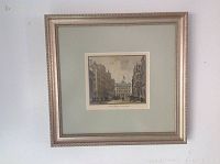 Framed artwork hanging on a white wall, showing the complete piece with visible mat and frame.