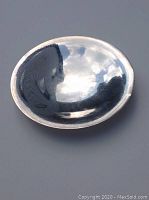 Top-down view of polished shallow silver dish showing interior surface and reflective finish