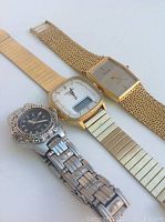 Three wristwatches laid flat: gold Accutron digital-analog, gold Bulova dress watch, and silver Arnivina with black dial.