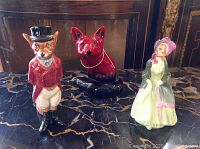 Overview of all three figurines on marble tabletop