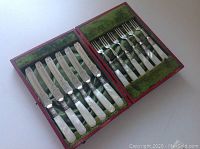 All six knives and six forks in original red presentation case with green velvet and satin lining