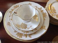 Stack of teacup on saucer atop salad and dinner plate showing pattern and shape