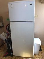 Front view of white top-freezer refrigerator showing overall condition and size.