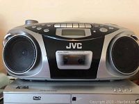 JVC portable CD player on top of Nona DVD player, showing front view of the audio system and DVD player controls