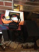 Group photo showing Logitech speakers with cables, Canon camera in carrying case, and two digital frames in boxes.