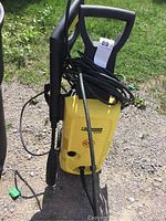 Front view of yellow Karcher pressure washer with handle, power cord, and hose wrapped around.