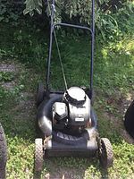 Front view of black Murray Select push lawn mower showing engine, wheels and handlebar, with visible dirt and wear.