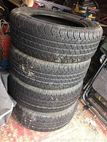 Stack of four used Road Handler Voyager LX tires showing tread and dirt marks.