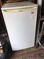 Full view of used white GoldStar refrigerator with worn surface.