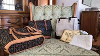 Full group image of five handbags and clutches on a patterned green upholstered chair