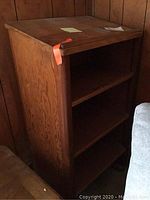 Front-side view of the wooden podium showing three shelves and wood grain texture