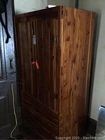 Full view of the cedar chifferobe cabinet showing two closed vertical doors and the natural wood grain.