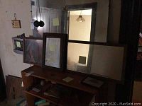 Four mirrors varying in size and frame style placed on furniture against a wall.