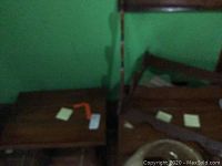 Two wooden end tables and wooden rifle racks visible to catalog all furniture and sporting items in the lot.