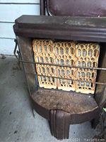 Front view of the vintage natural gas space heater showing the heating elements and protective grills.