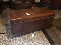 Top-down view of wooden Lane chest with rounded front edges, dark finish and flat lid, placed on patterned floor.
