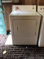 Front view of the Estate gas dryer showing the door, handle, and control panel with knob and cycle selector.