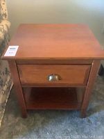 Front view of the wood end table showing the drawer and bottom shelf.