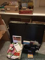 Craft Master instant projector with manual, black device with handle and focus knob, along with assorted craft papers and coloring books.