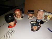 Five Toby mugs with character designs displayed on a white surface, including Guardsmen, Bootmaker, Ben Franklin, Beefeater and Rip Van Winkle.