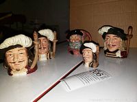 Front view of the five Toby mugs showing faces of Porthos, Athos, Aramis, Falstaff, and miniature Athos.