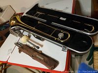 Overview of trombone, case interior, canvas bag and metal rest stand