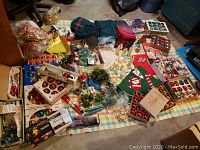 Overview of Christmas decorations on table showing boxed ornaments, wreaths, and various holiday items spread out