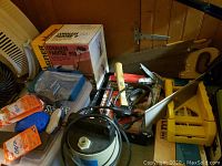 Photo of boxed Wagner Cordless Painter 919 with saws, an air pump, and other small tools and accessories on a table