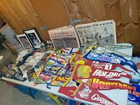 Overview of table with pennants, newspapers, bobbleheads, and framed photos