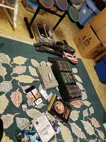 Overview of PSone console, Guitar Hero guitars and drum set with games and cables in background