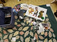 Overview of all items including PlayStation 2 console, magazines, game cases, and accessories spread on carpet