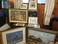 Overall lot of seven framed prints arranged on floor and trunk