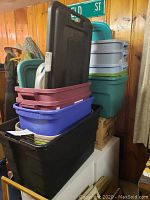 Full stack of plastic storage bins and lids in various colors and sizes, showing the quantity of 13 bins packed together.