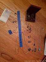 Full assortment of rings, chains, earrings displayed on wood