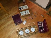 Overview of costume jewelry cases, loose jewelry, and weather wall art on floor.