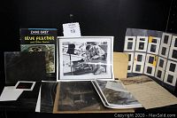 Collection of items on display including the hard cover book Blue Feather and Other Stories, black & white photos, antique glass negative, letters, and slides in display sheets.