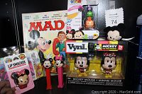 Photo showing Lot including boxed Vynl Mickey and Minnie Mouse figures, vintage Mad Magazine with Mickey on cover, two vintage PEZ dispensers, Tsum Tsum figures pack, and Minnie Mouse Lip Smacker in packaging