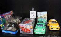 Photo showing four Chevron Cars toy vehicles on shelf: black Patty Patrol in packaging, red Tony Turbo in box, green Wendy Wagon with Owner's Manual, yellow Tyler Taxi.