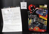 Overall shot of the Batcycle collectible in original packaging alongside the Certificate of Authenticity from George Barris estate on black background.