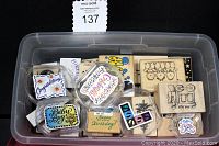 Clear plastic tote filled with assorted vintage rubber stamps including various designs and sizes.