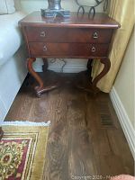Front and side view of mahogany side table showing overall design with two drawers and curved legs.