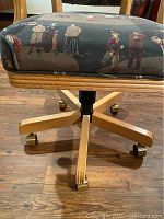 Close-up of chair base and upholstery pattern showing swivel mechanism and caster wheels