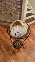 Front view of floor-standing globe on metal stand.