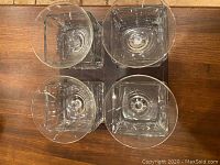 Top view of four square-bowled martini glasses arranged on a wooden surface, seen from above showing the shape and arrangement.