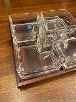 Close-up side view of the glass containers on the wooden tray showing the thickness and clear appearance of the glass containers.