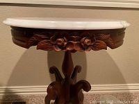 Close-up of carved wood apron and marble edge