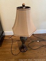 Photo of the turned off 3-way table lamp showing beige fabric shade and ornate metal and wood base