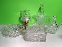 Full lot view showing all four glass items against green background: Waterford votive, dresser box with bird finial, pressed glass basket, and round bowl.